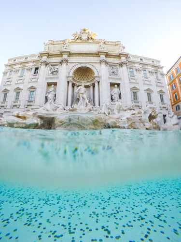 underwater shot of coins at trevi fountain